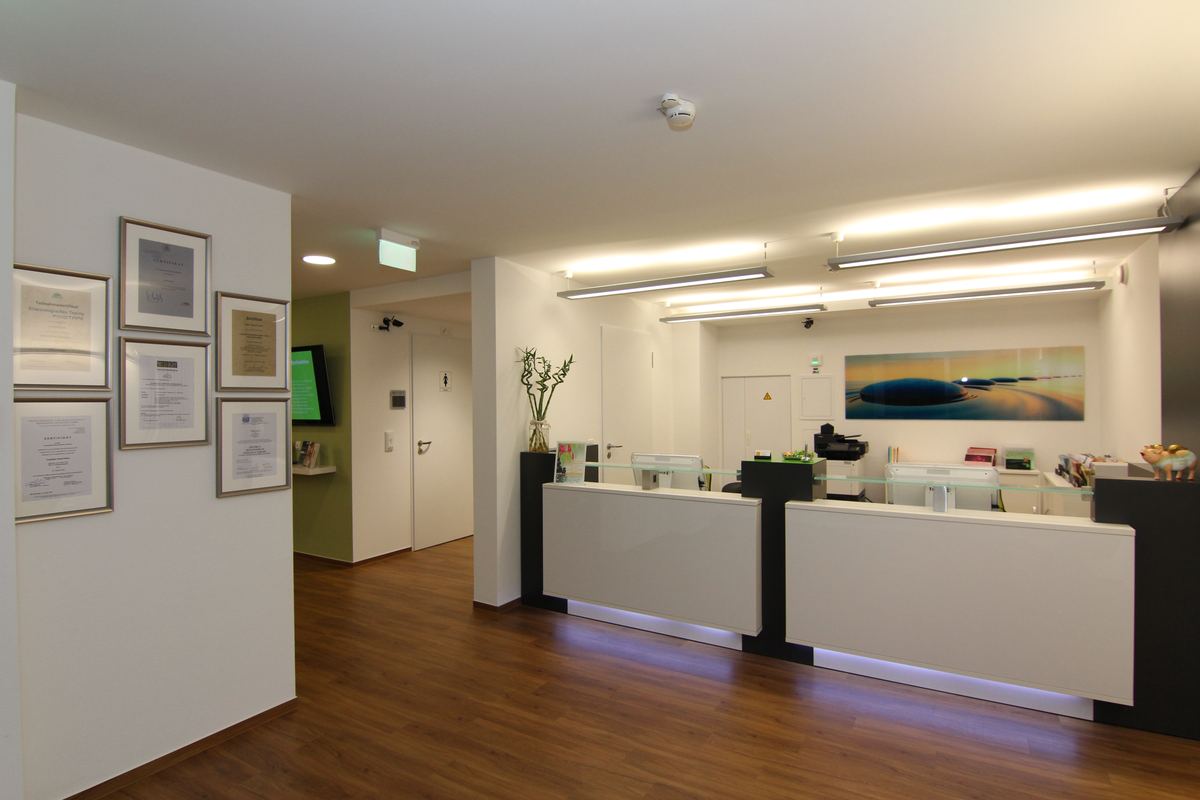 Empfangshalle des Therapiezentrums Dentl mit hellem Tresen und langem Flur